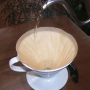 コーヒーの濾過をするための濾紙があります。濾紙に向かってお湯が注がれています。